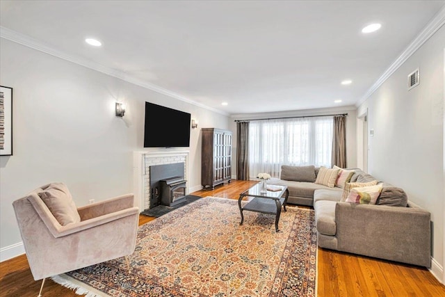 living room featuring visible vents, baseboards, wood finished floors, crown molding, and recessed lighting