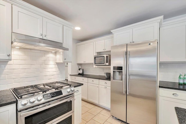 kitchen with dark countertops, under cabinet range hood, white cabinets, and stainless steel appliances