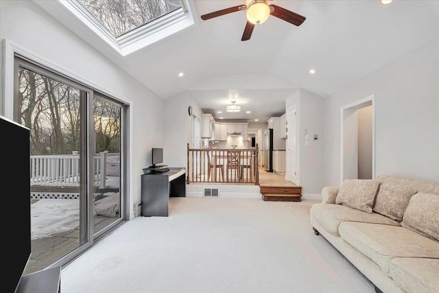 living area with lofted ceiling with skylight, light colored carpet, visible vents, and recessed lighting