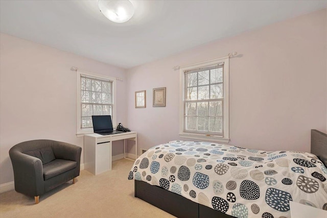 bedroom with baseboards and light colored carpet