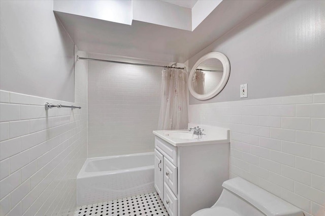 full bath featuring wainscoting, toilet, tile walls, and vanity