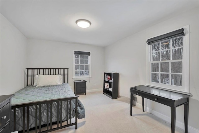 bedroom featuring light carpet and baseboards