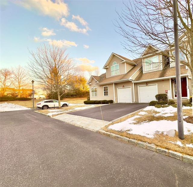 view of property with a garage and driveway