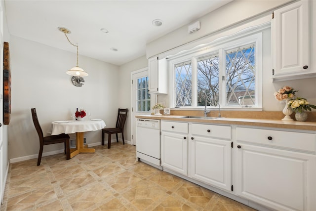 kitchen with light countertops, pendant lighting, white cabinets, and dishwasher