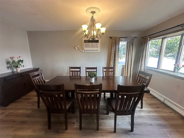 dining room with a baseboard radiator, a wall mounted air conditioner, a notable chandelier, and wood finished floors