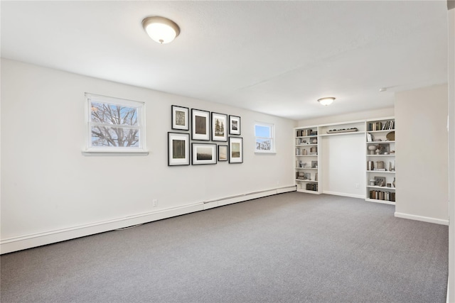 basement featuring carpet floors, baseboards, and a baseboard heating unit