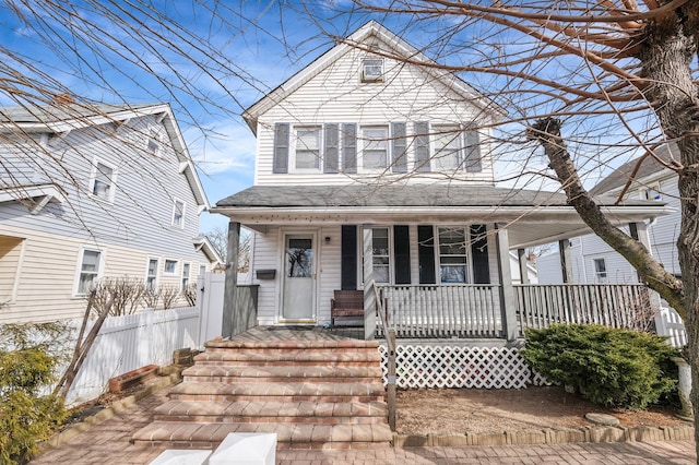 view of front facade featuring a porch and fence