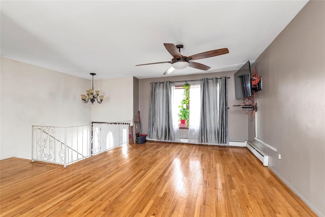 empty room featuring baseboard heating, baseboards, light wood finished floors, and ceiling fan with notable chandelier