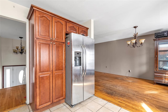 kitchen featuring an inviting chandelier, light tile patterned floors, stainless steel refrigerator with ice dispenser, and decorative light fixtures