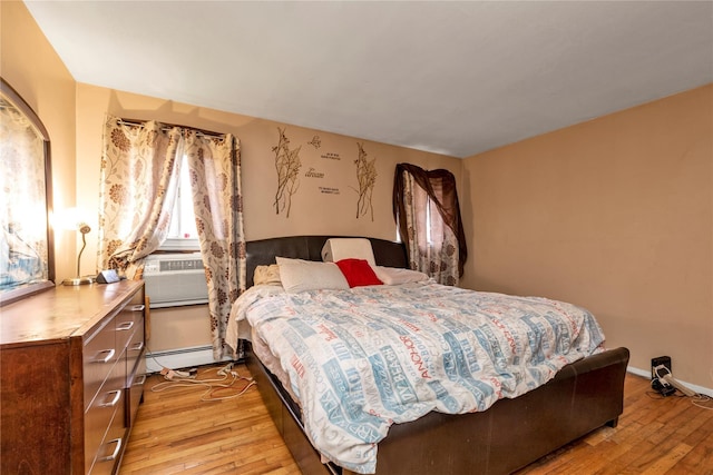 bedroom featuring light wood-style floors, baseboards, a baseboard heating unit, and cooling unit