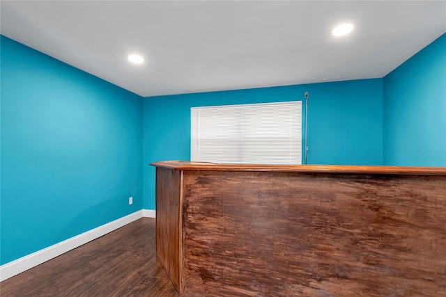 bar featuring dark wood-type flooring, recessed lighting, a dry bar, and baseboards