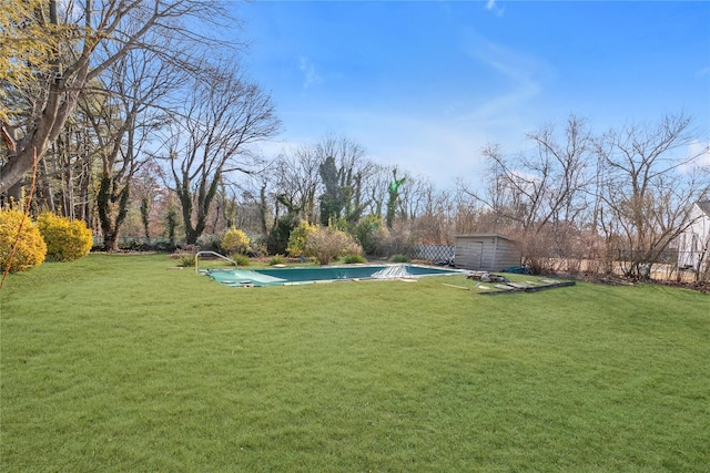 view of yard with a storage shed, an outdoor structure, fence, and a covered pool