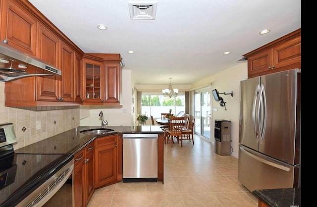 kitchen with visible vents, glass insert cabinets, appliances with stainless steel finishes, extractor fan, and a sink