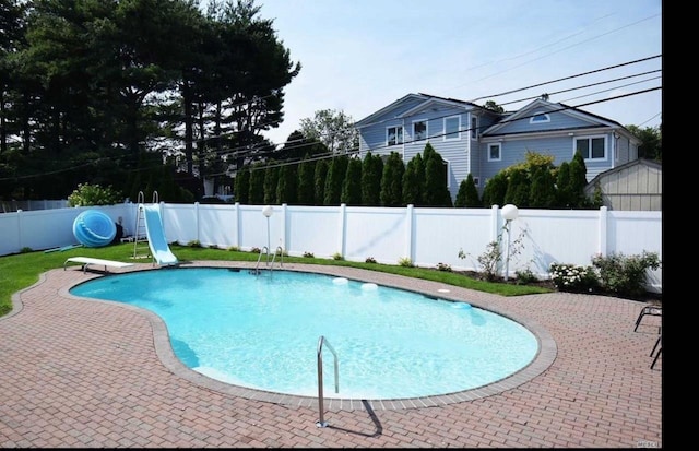 view of swimming pool with a fenced in pool, a patio, a water slide, a fenced backyard, and a diving board