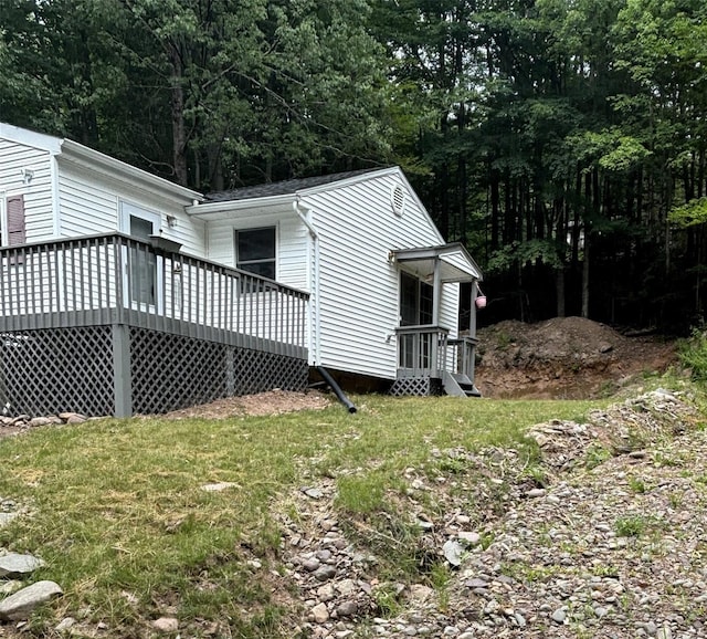 view of property exterior with a yard and a wooden deck