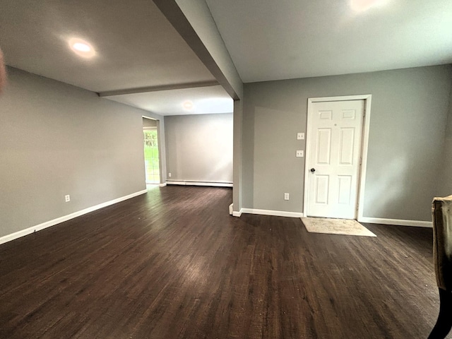 unfurnished room featuring a baseboard heating unit, dark wood finished floors, and baseboards