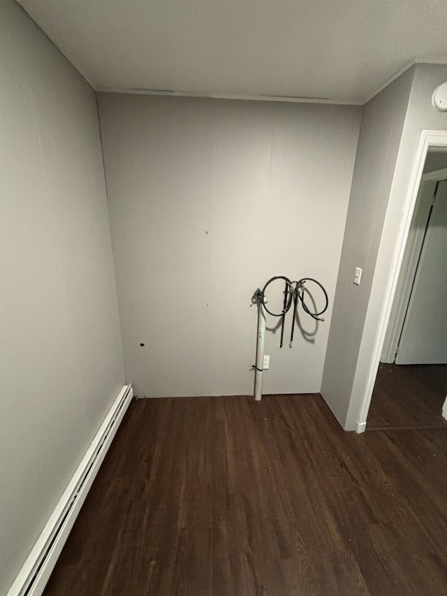 clothes washing area featuring a baseboard radiator and dark wood finished floors