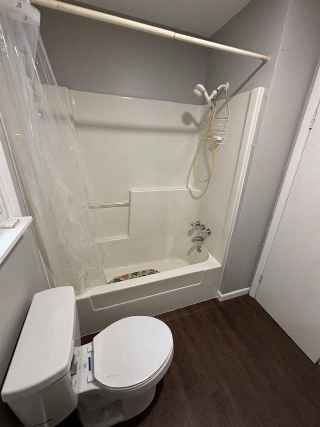 bathroom featuring shower / bathtub combination with curtain, toilet, and wood finished floors