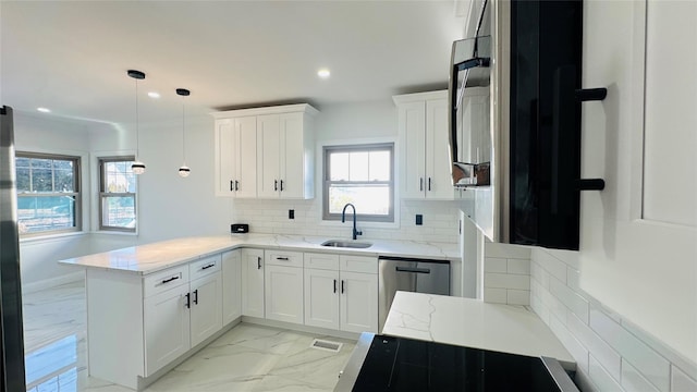 kitchen featuring a peninsula, marble finish floor, white cabinetry, pendant lighting, and a sink