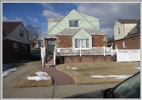 bungalow-style home with brick siding and fence