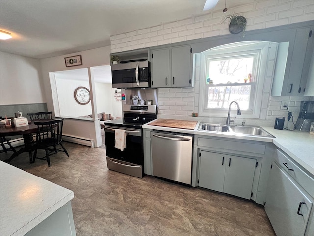 kitchen with stainless steel appliances, tasteful backsplash, a sink, and light countertops