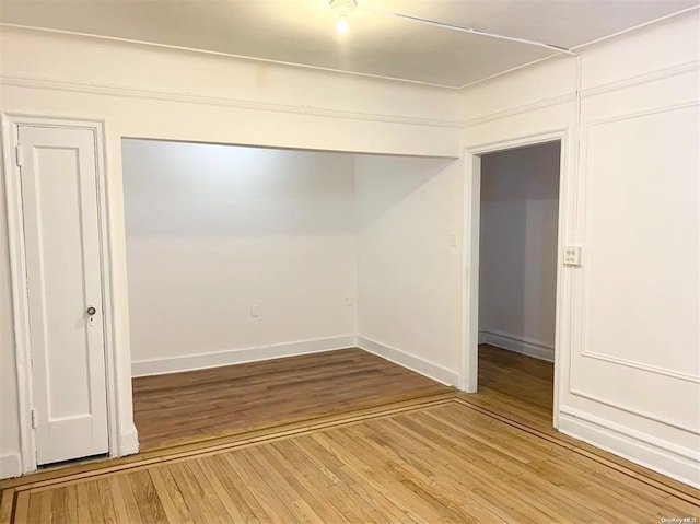 unfurnished bedroom with a closet, baseboards, and wood finished floors