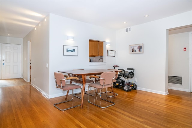 dining room featuring light wood-style floors, visible vents, and baseboards