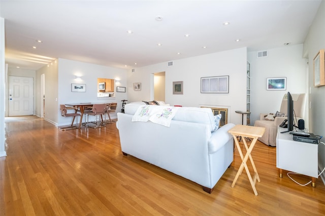 living area with light wood-type flooring, visible vents, and recessed lighting