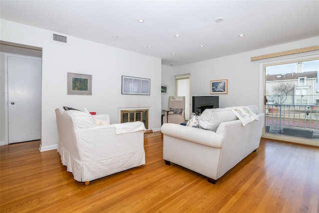 living room with baseboards, recessed lighting, visible vents, and light wood-style floors