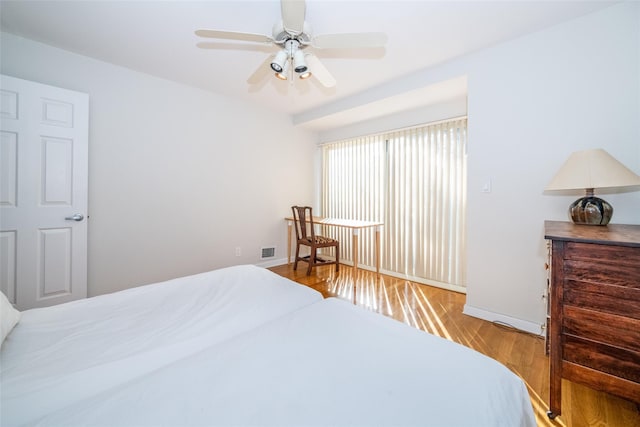 bedroom with visible vents, ceiling fan, baseboards, and wood finished floors