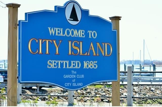 community / neighborhood sign featuring fence