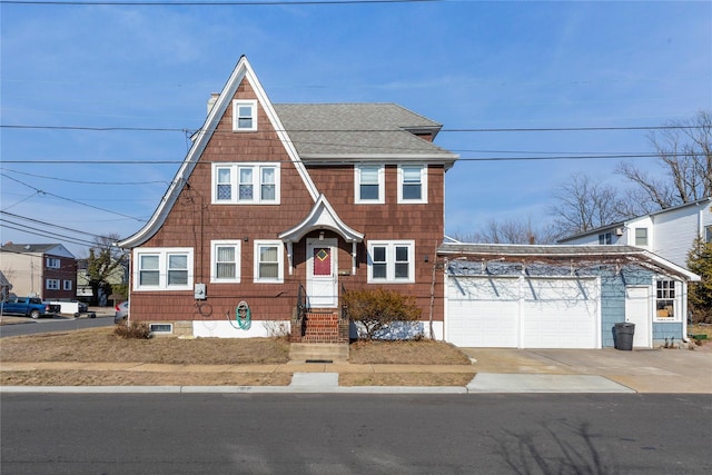 view of front of property featuring a garage, a shingled roof, a chimney, and concrete driveway