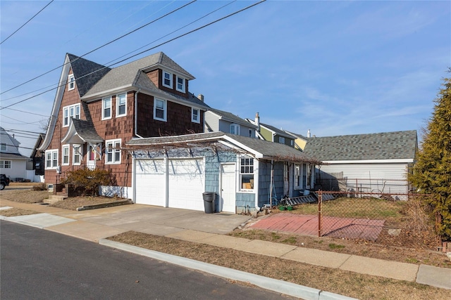 view of front facade featuring roof with shingles and driveway