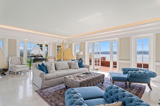 living room featuring crown molding, a raised ceiling, and a healthy amount of sunlight