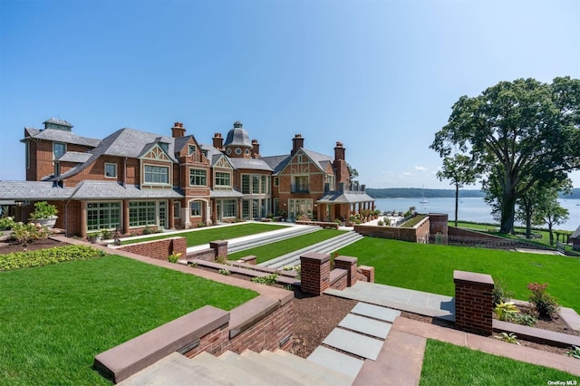 view of home's community with a water view and a yard