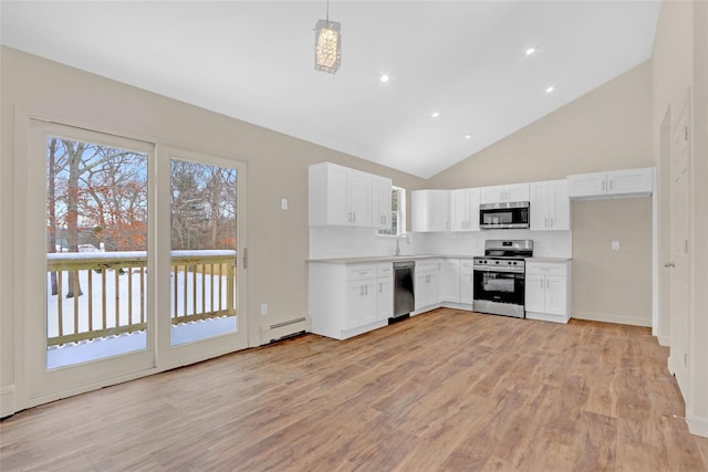 kitchen with a baseboard heating unit, white cabinets, light countertops, appliances with stainless steel finishes, and decorative light fixtures