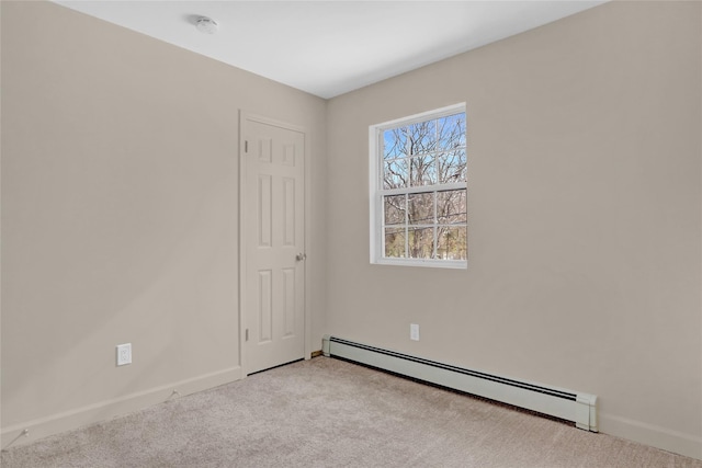 spare room with light carpet, baseboards, and a baseboard heating unit