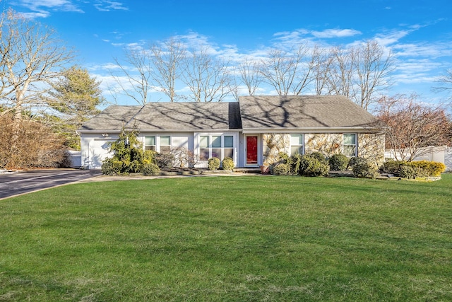 ranch-style home featuring a garage and a front lawn
