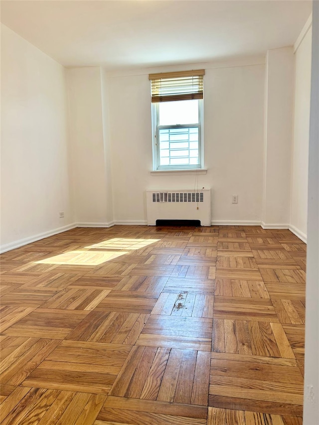 unfurnished room featuring radiator heating unit and baseboards