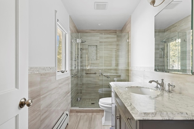 bathroom featuring toilet, visible vents, vanity, tile walls, and a stall shower