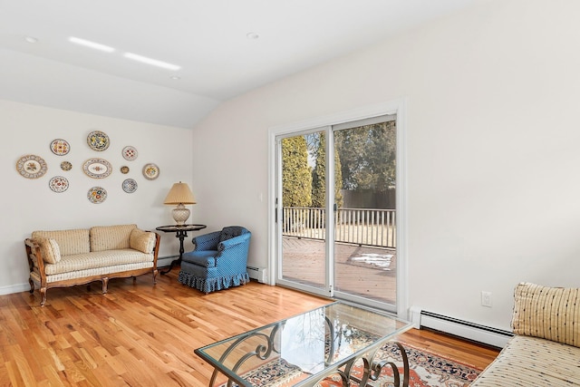 sitting room featuring a baseboard heating unit, vaulted ceiling, and wood finished floors