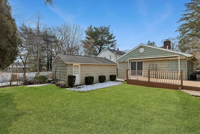 back of house with a chimney, fence, a deck, and a lawn