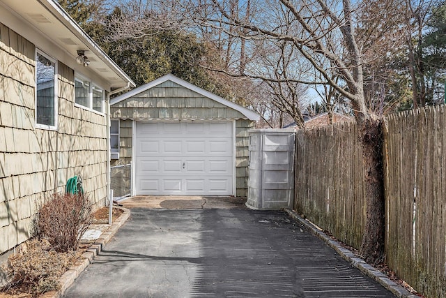 detached garage with fence and driveway