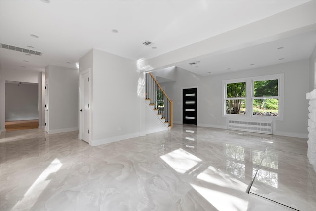 unfurnished living room with marble finish floor, visible vents, stairway, radiator heating unit, and baseboards