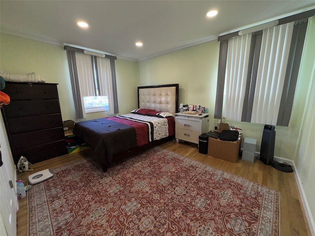 bedroom featuring wood finished floors, recessed lighting, and ornamental molding