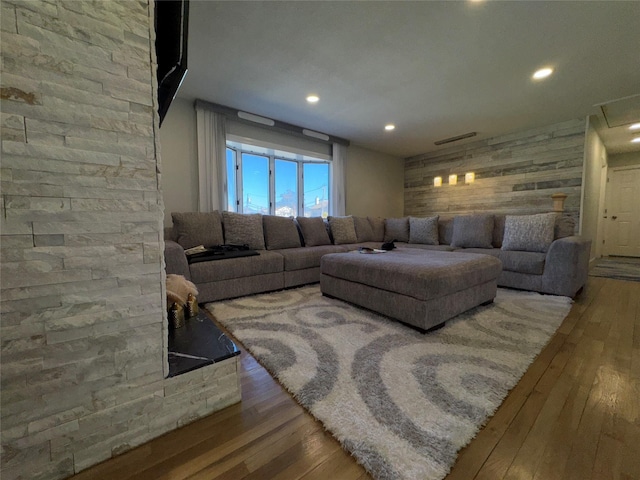 living room with wood walls, hardwood / wood-style floors, and recessed lighting