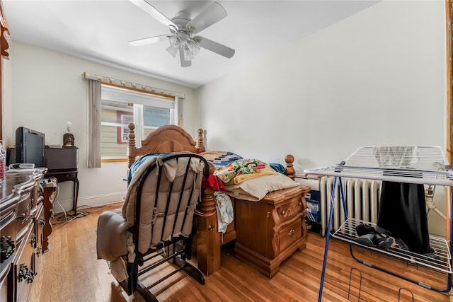 bedroom featuring wood finished floors, a ceiling fan, and baseboards