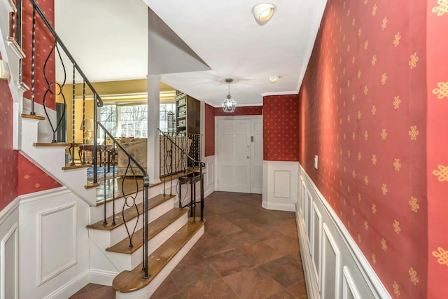 interior space with ornamental molding, wainscoting, decorative columns, and wallpapered walls