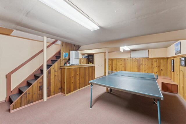 rec room featuring light carpet, a wainscoted wall, and wooden walls