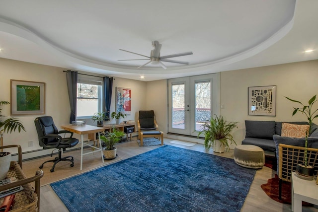 office area featuring a tray ceiling, wood finished floors, french doors, and ceiling fan